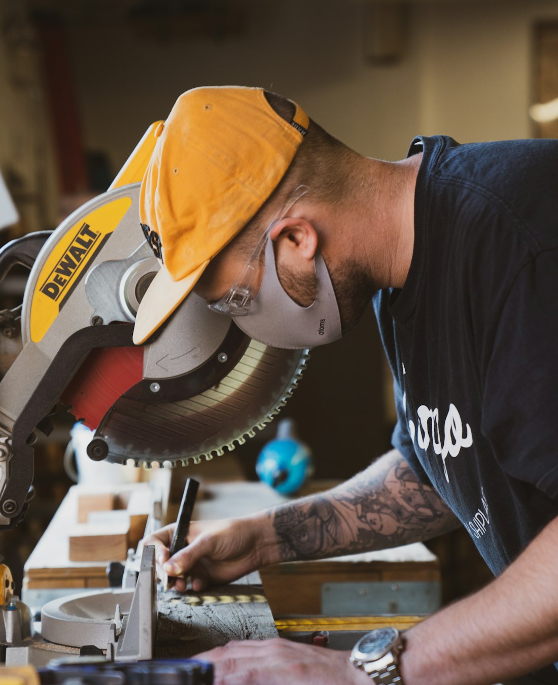 A joiner working at a mitre saw in his workshop